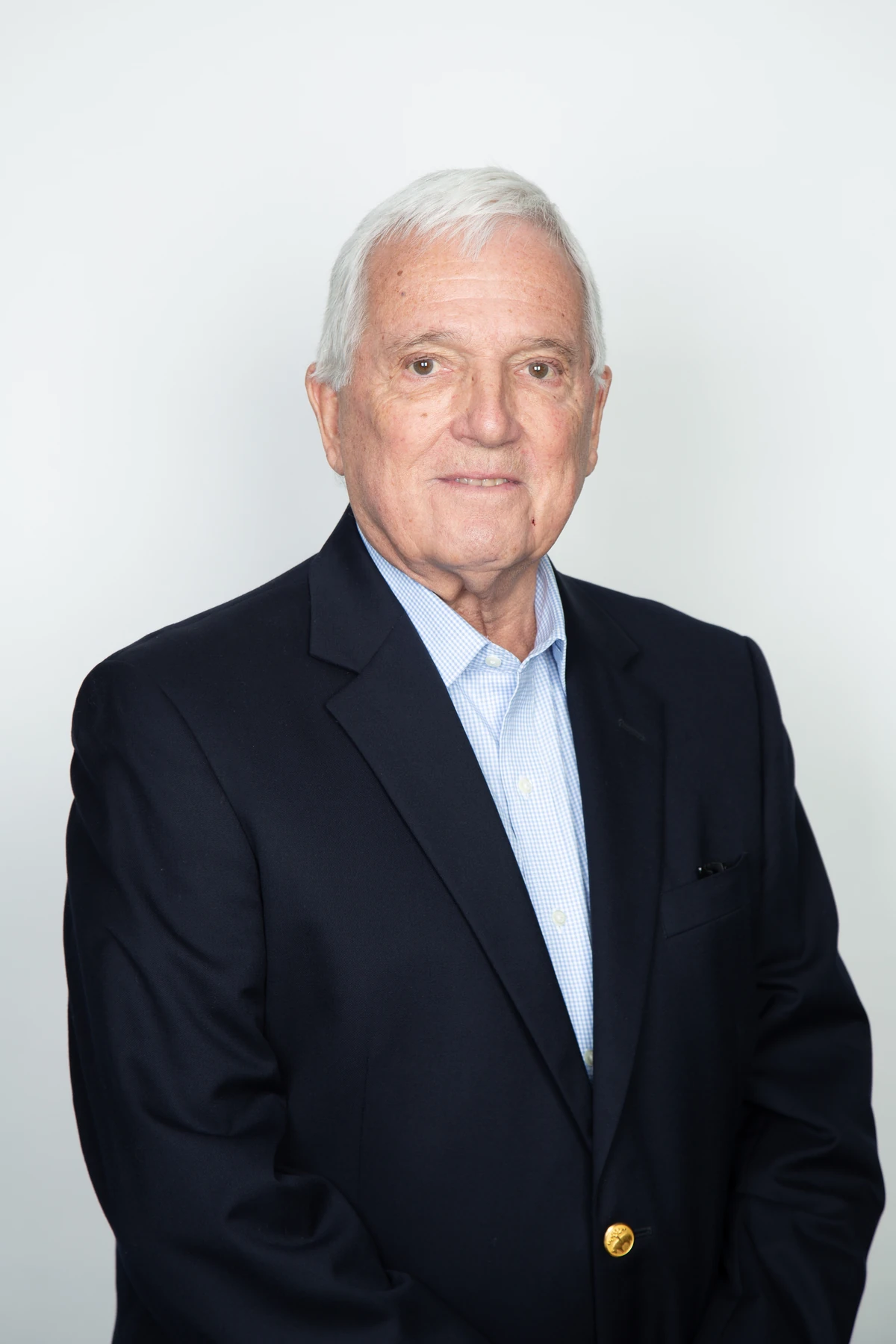 Retrato corporativo para Megacentro con chaqueta oscura y camisa azul sobre fondo claro